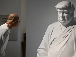 In a craftsman's workshop in China, a statue of US President-elect Trump sits in divine contemplation